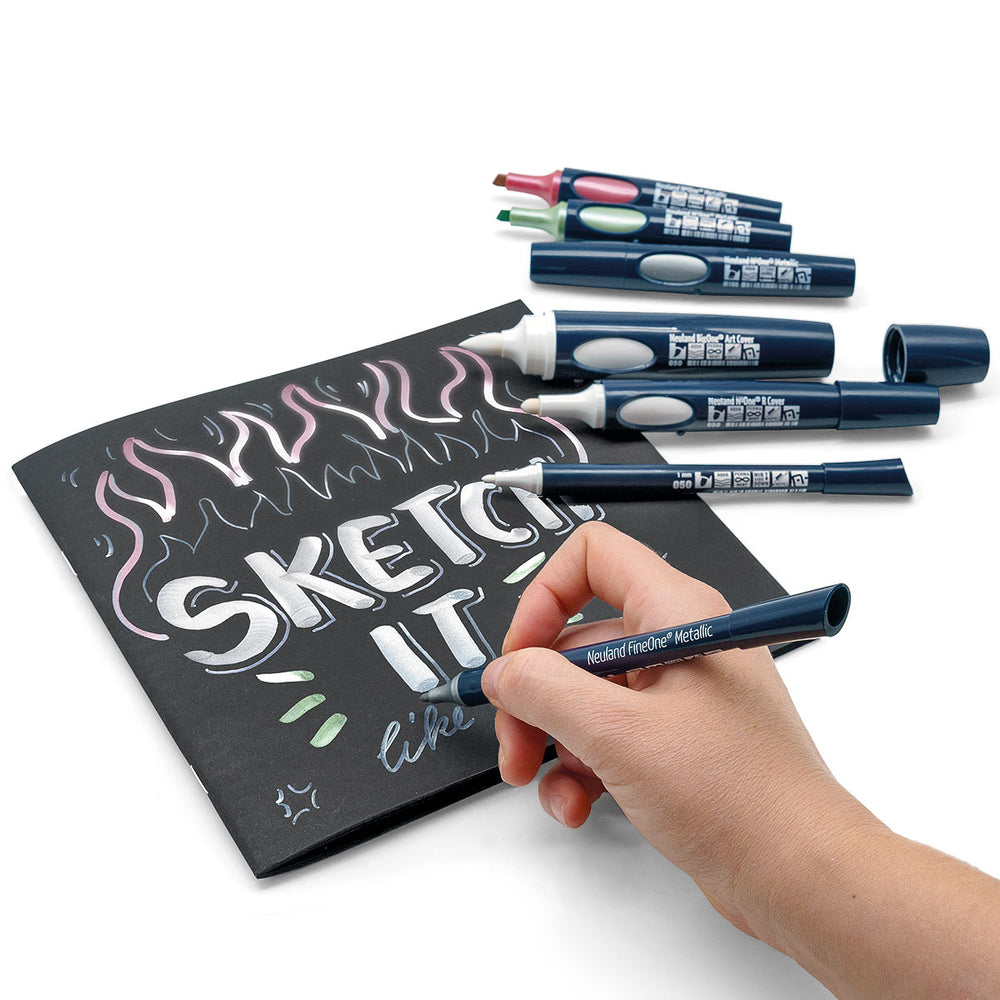 Neuland white Cover marker pen range and metallic colours used on black paper. Neuland products sold in the UK by official reseller, Inky Thinking.