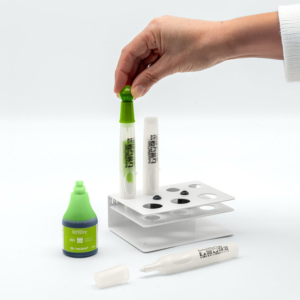 Photo showing neuland marker pen being refilled with green ink at refill station. 