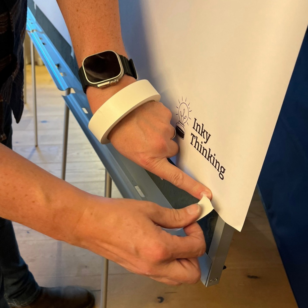 Person sticking paper to graphicwall with Artist Tape, safe tape for paper