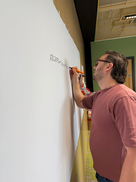 Man writing on a whiteboard with a marker in an indoor setting with Heather Martinez in collab with Inky Thinking