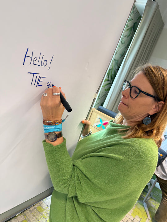 Person writing 'Hello!' on a whiteboard with a marker. Workshop with Heather Martinez in collab with Inky Thinking