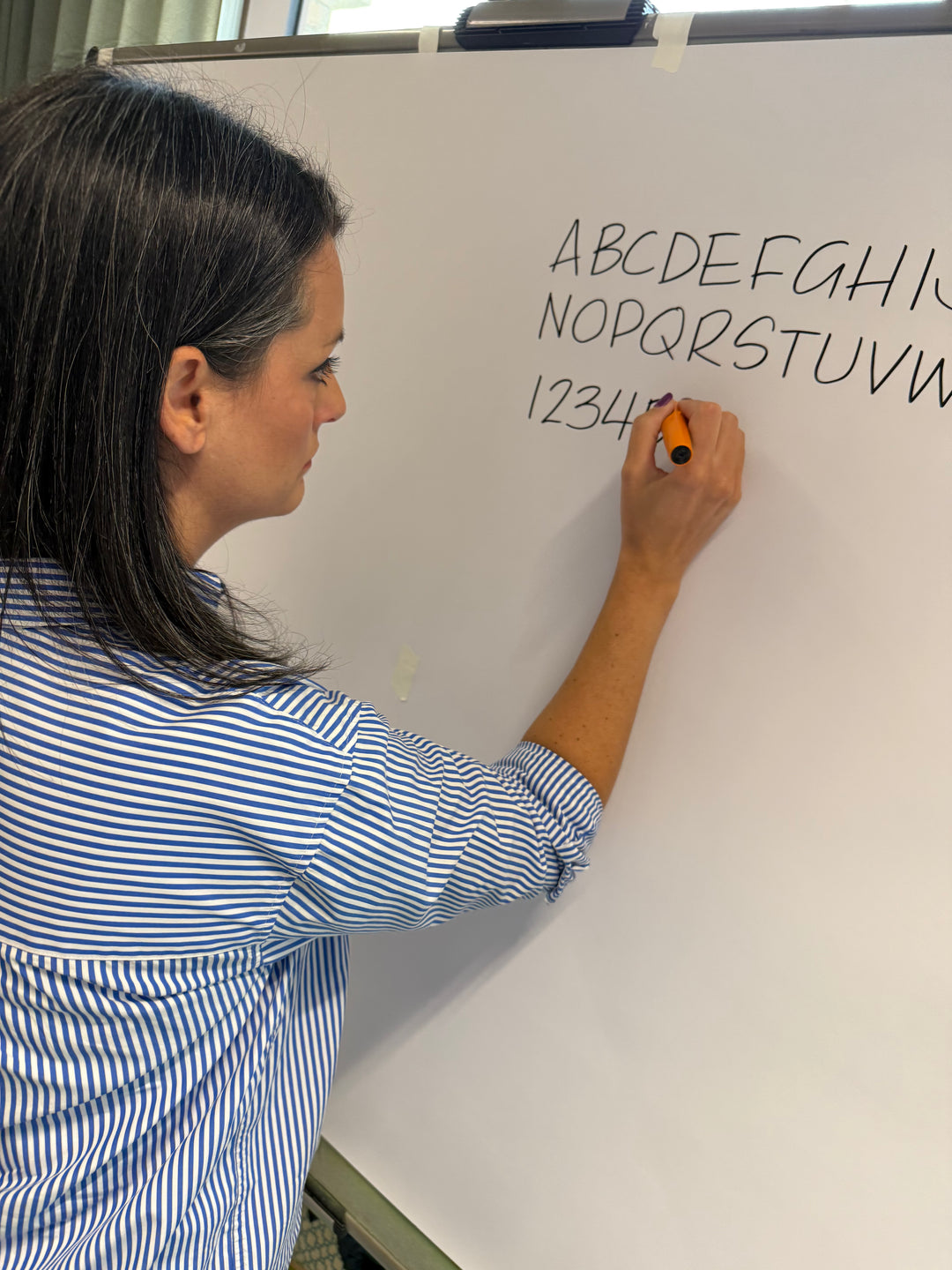 Person writing on a whiteboard with letters and numbers with Heather Martinez in collab with Inky Thinking