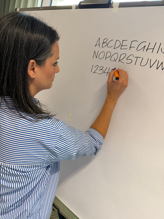 Person writing on a whiteboard with letters and numbers with Heather Martinez in collab with Inky Thinking
